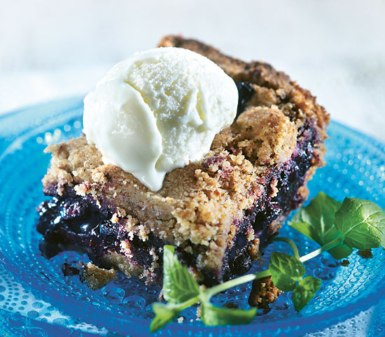 Blueberry pie-like dessert with a scoop of vanilla ice cream.