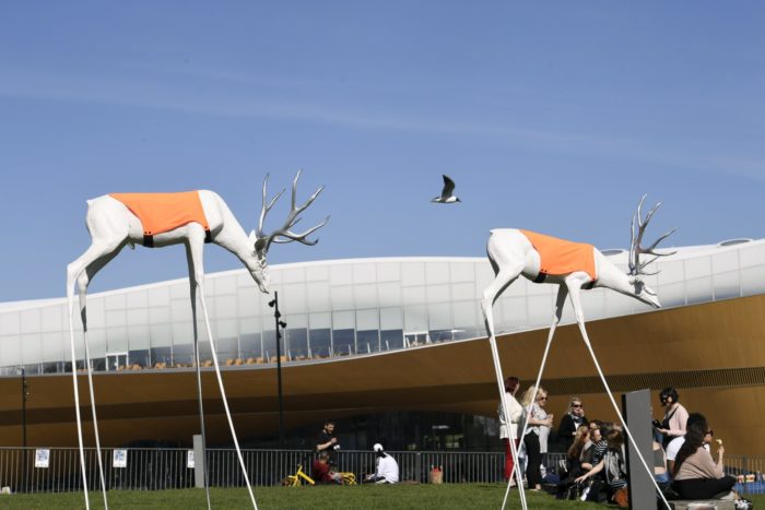 Tall-legged reindeer sculptures in front of Oodi library.