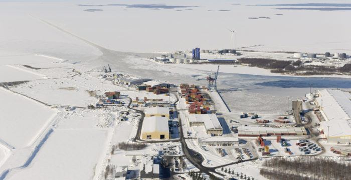 The buildings of a harbour terminal stand in a snowy landscape.