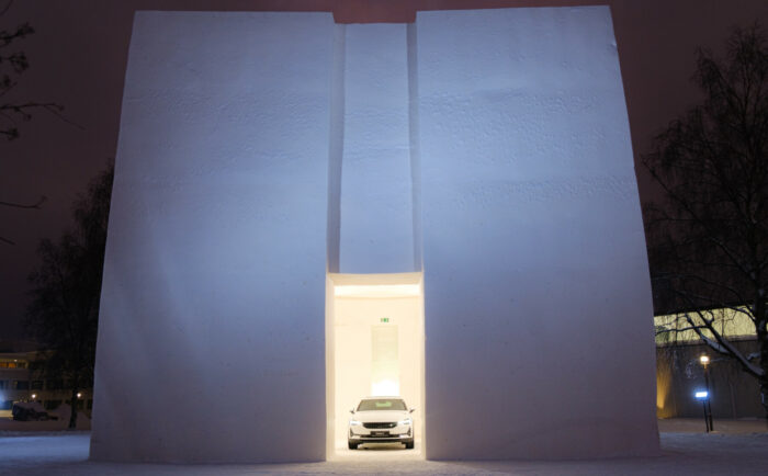 A car stands in an archway in a building made of snow.