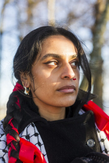 A portrait of a woman in front of a forest background.